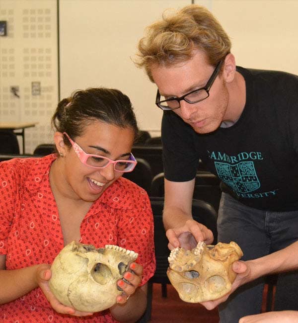 Photo of students examining primate skulls